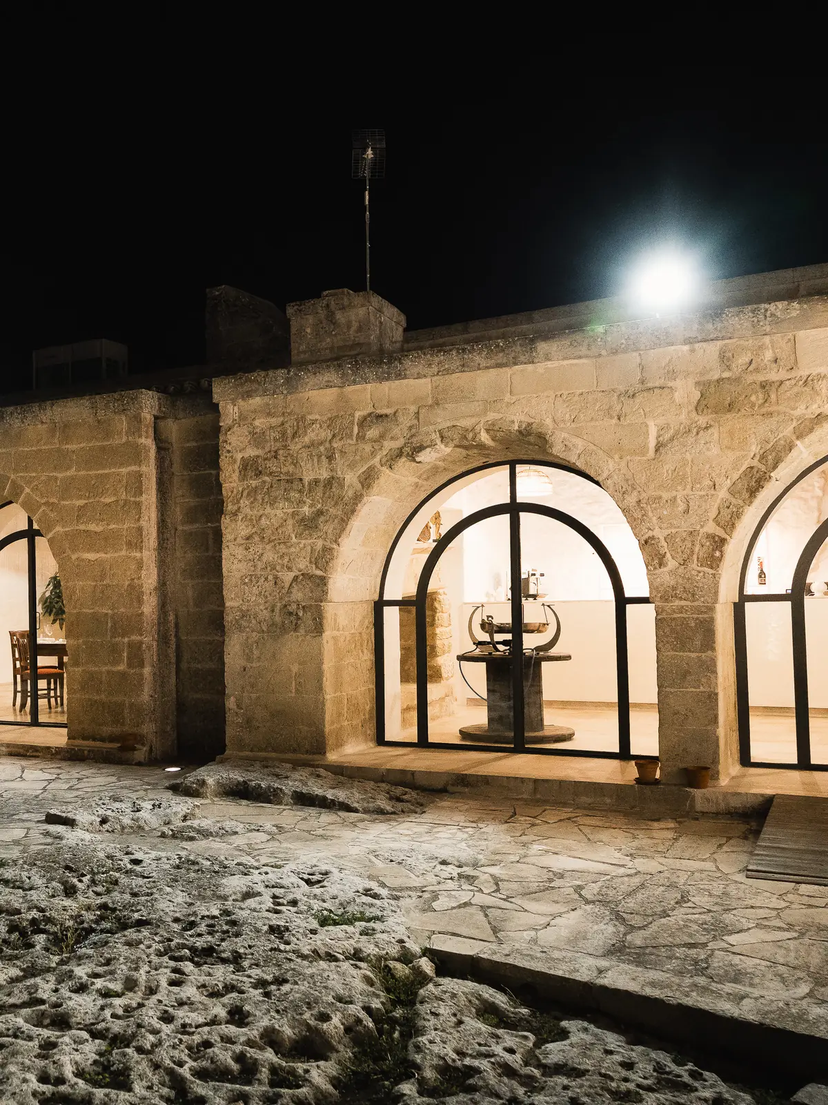 Gli archi della masseria illuminati nella sera, pronti per una festa